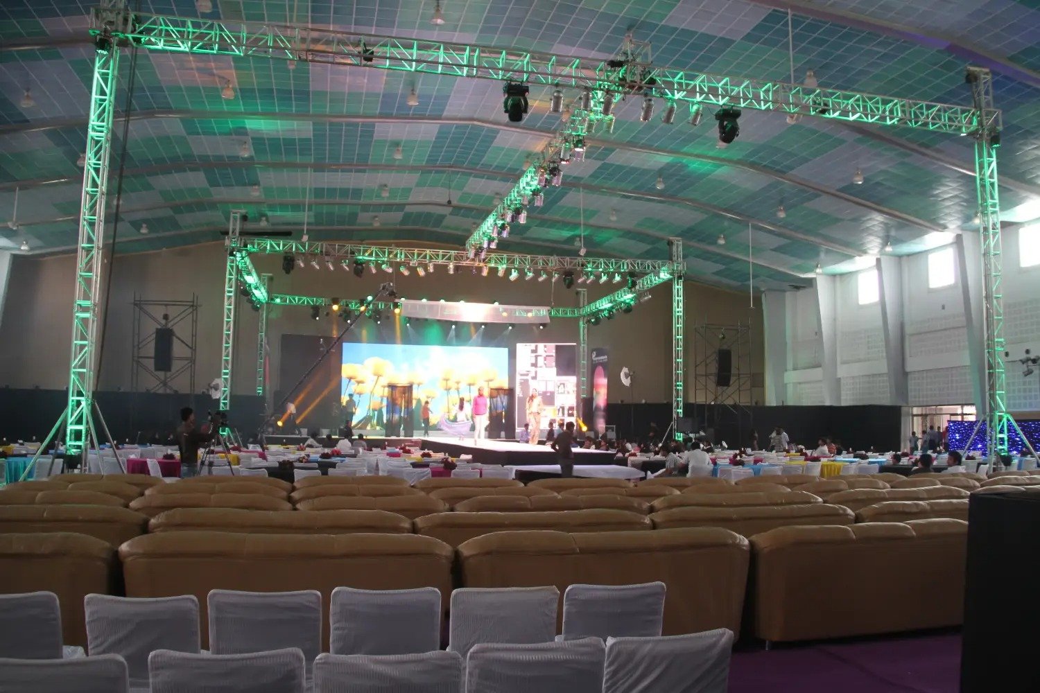 Man and woman speaking on stage at night with blue lighting